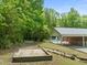 Backyard featuring a pool, covered patio, horseshoe pit, and wooded areas at 1514 Lawrence Rd, Creedmoor, NC 27522