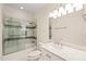 Well-lit bathroom with white marble countertop vanity and glass door to tub and shower at 1514 Lawrence Rd, Creedmoor, NC 27522