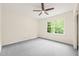 A bright, carpeted bedroom with a ceiling fan and a large window at 1514 Lawrence Rd, Creedmoor, NC 27522
