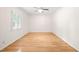 Bedroom features neutral walls, hardwood flooring, and a large window providing natural light at 1514 Lawrence Rd, Creedmoor, NC 27522