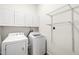 Laundry room with white washer, dryer, cabinets and wire shelving at 1514 Lawrence Rd, Creedmoor, NC 27522