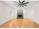 Bright living room with hardwood floors, stone fireplace, and a modern ceiling fan, creating a welcoming space at 1514 Lawrence Rd, Creedmoor, NC 27522