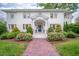Charming two-story brick home featuring a blue front door and lush, landscaped front yard at 1519 Hermitage Ct, Durham, NC 27707