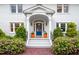Inviting front entrance with a vibrant blue door, white pillars, and colorful flower pots at 1519 Hermitage Ct, Durham, NC 27707