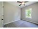 Neutral bedroom with gray carpet, ceiling fan, and a window view of lush greenery at 152 Chauncey Cir, Chapel Hill, NC 27516