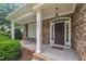 Charming front porch featuring stone accents, white columns, and a stylish front door at 1608 Heritage Links Dr, Wake Forest, NC 27587