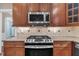 Modern kitchen featuring stainless steel appliances, granite countertops, and wooden cabinetry at 1608 Heritage Links Dr, Wake Forest, NC 27587