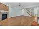 Open living room featuring a stone fireplace, hardwood floors, and staircase at 1608 Heritage Links Dr, Wake Forest, NC 27587