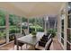 Inviting screened porch with a dining table offers serene outdoor living and neighborhood views through large windows at 1608 Heritage Links Dr, Wake Forest, NC 27587