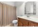 Bathroom featuring a vanity with wood cabinets, a white sink, decorative mirror and shower with curtain at 166 Daffodil Ln, Clayton, NC 27527