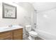 Bathroom featuring a vanity with wood cabinets, a white sink, decorative mirror, toilet and shower at 166 Daffodil Ln, Clayton, NC 27527