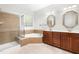 Elegant bathroom featuring a glass-enclosed shower, corner tub, and double vanities with stylish mirrors and lighting at 166 Daffodil Ln, Clayton, NC 27527