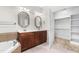 Spacious bathroom with double vanities, a soaking tub, and a walk-in closet for a luxurious experience at 166 Daffodil Ln, Clayton, NC 27527