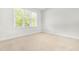 Bright bedroom featuring a large window letting in natural light and neutral carpet at 166 Daffodil Ln, Clayton, NC 27527