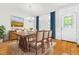 Formal dining room with hardwood floors, elegant chandelier, and large window with blue curtains at 166 Daffodil Ln, Clayton, NC 27527