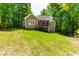Charming home with a green exterior, a screened porch, and a well-maintained lawn in a wooded setting at 166 Daffodil Ln, Clayton, NC 27527