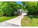 Home with an extended driveway, well-maintained lawn, and surrounded by mature trees at 166 Daffodil Ln, Clayton, NC 27527