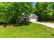 Beautifully landscaped front yard with lush greenery and a charming home nestled in trees at 166 Daffodil Ln, Clayton, NC 27527