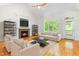 Cozy living room with fireplace, hardwood floors, comfortable seating and natural light at 166 Daffodil Ln, Clayton, NC 27527