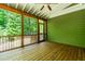 Relaxing screened porch with wooden floors and ceiling fan, overlooking a lush green landscape at 166 Daffodil Ln, Clayton, NC 27527