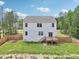 A view of the rear of the home featuring the second story windows and the wooden deck with stairs to the yard at 170 Baker Farm Dr, Youngsville, NC 27596