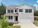Charming two-story home with gray siding, black shutters, a covered porch, and a two-car garage at 170 Baker Farm Dr, Youngsville, NC 27596