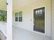 Covered front porch, black front door with glass, white railings, and landscaped shrubbery at 170 Baker Farm Dr, Youngsville, NC 27596