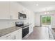 Modern kitchen featuring stainless steel appliances, white cabinets, granite countertops and a sliding glass door at 170 Baker Farm Dr, Youngsville, NC 27596