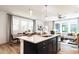 Open-concept kitchen with a large island, stainless steel dishwasher, and views of the living area at 18 Relaxing Way, Pittsboro, NC 27312