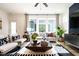 Inviting living room featuring a gray sofa, patterned rug, and a view to the outside through large windows at 18 Relaxing Way, Pittsboro, NC 27312