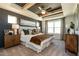 Luxurious main bedroom with a tray ceiling, stylish decor, and large windows at 18 Relaxing Way, Pittsboro, NC 27312