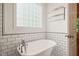 Bathroom with a free-standing tub, subway tile, and chrome fixtures at 1870 Lennox Dr, Garner, NC 27529