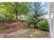Backyard view with landscaping, green grass, and a patio; perfect for outdoor enjoyment at 2010 Silky Dogwood Trl, Apex, NC 27502