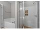 Modern bathroom featuring a glass enclosed shower, a soaking tub, and neutral tile at 2010 Silky Dogwood Trl, Apex, NC 27502