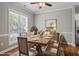 Dining room with a wooden table, neutral chairs, and decorative accents creating a warm, inviting space at 2010 Silky Dogwood Trl, Apex, NC 27502