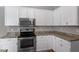 Bright kitchen with white cabinets, granite countertops, and stainless steel oven and cooktop at 2010 Silky Dogwood Trl, Apex, NC 27502