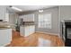 Bright kitchen showcases white cabinets, granite counters, wood floors and adjacent breakfast area at 2010 Silky Dogwood Trl, Apex, NC 27502