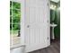 Elegant bathroom features modern fixtures, pedestal sink, and a door leading to the outdoor patio at 2018 Grassy Banks Dr, Raleigh, NC 27610