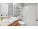 Bright bathroom with vanity, toilet, metal shelving and shower-tub combination at 2018 Grassy Banks Dr, Raleigh, NC 27610