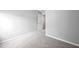 Carpeted bedroom with neutral gray walls, two outlets, and an open door to a hallway at 2018 Grassy Banks Dr, Raleigh, NC 27610