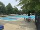Community pool area with a table and chairs surrounded by green trees at 2018 Grassy Banks Dr, Raleigh, NC 27610