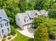 Aerial view of a house showcasing a two-car garage, well-maintained lawn and mature trees at 203 Witheridge Ct, Apex, NC 27502