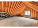 Unfinished attic space with exposed wooden beams, a plywood floor, ductwork, and a window at 203 Witheridge Ct, Apex, NC 27502