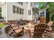 A backyard patio with a stone firepit surrounded by Adirondack chairs with an exterior view of the home at 203 Witheridge Ct, Apex, NC 27502