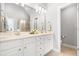 Elegant bathroom featuring double sinks, white cabinetry, a large mirror, and tiled floors at 203 Witheridge Ct, Apex, NC 27502
