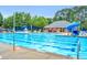 Large community pool surrounded by lounge chairs, tables and umbrellas with a slide for added fun at 203 Witheridge Ct, Apex, NC 27502