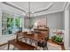 Bright dining room with large windows, tray ceiling, modern chandelier, and neutral walls at 203 Witheridge Ct, Apex, NC 27502