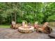 Cozy outdoor firepit with a stone surround and Adirondack chairs on a paver patio at 203 Witheridge Ct, Apex, NC 27502