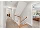 Upstairs hallway leading to bedroom, features hardwood stairs and carpet at 203 Witheridge Ct, Apex, NC 27502