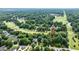 An aerial view shows a neighborhood street, trees, golf course, and single Gathering homes at 204 Muirfield Ln, Clayton, NC 27527